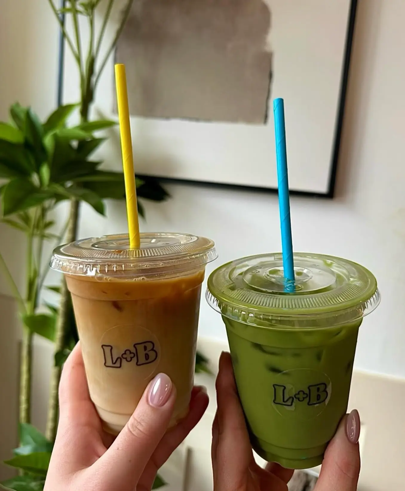 Two Leaf + Bean branded takeaway cups holding an iced latte and an iced matcha