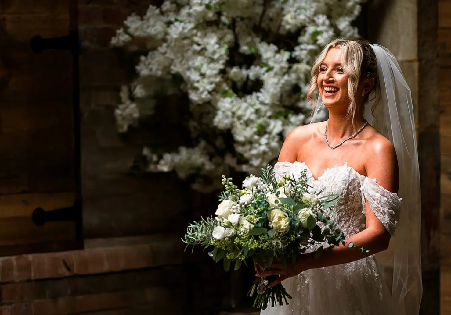 A trailing white bridal bouquet with roses and gypsophila