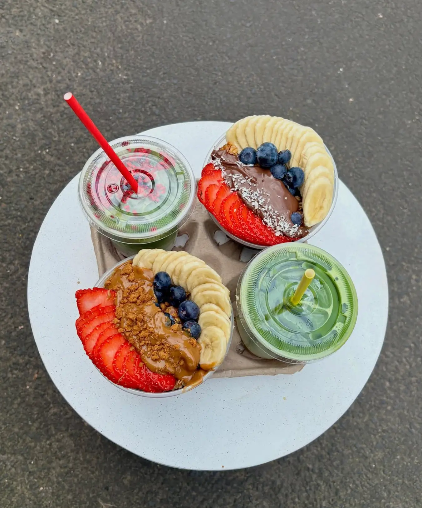 Takeaway acai bowls and iced matcha in a carry tray, photographed from above